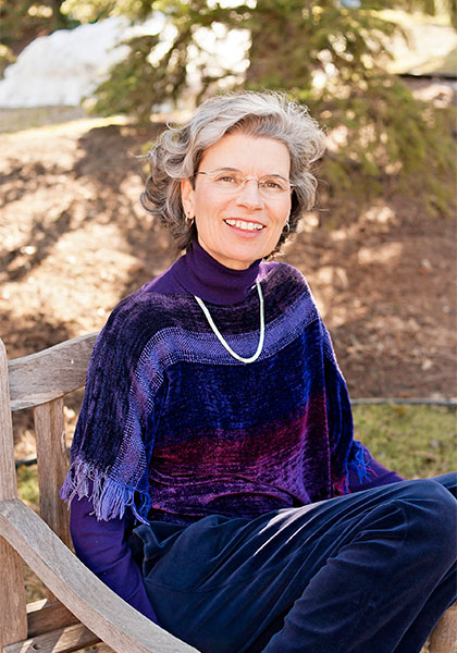 Photograph of Teresa Diffley sitting outside in a wooden chair.